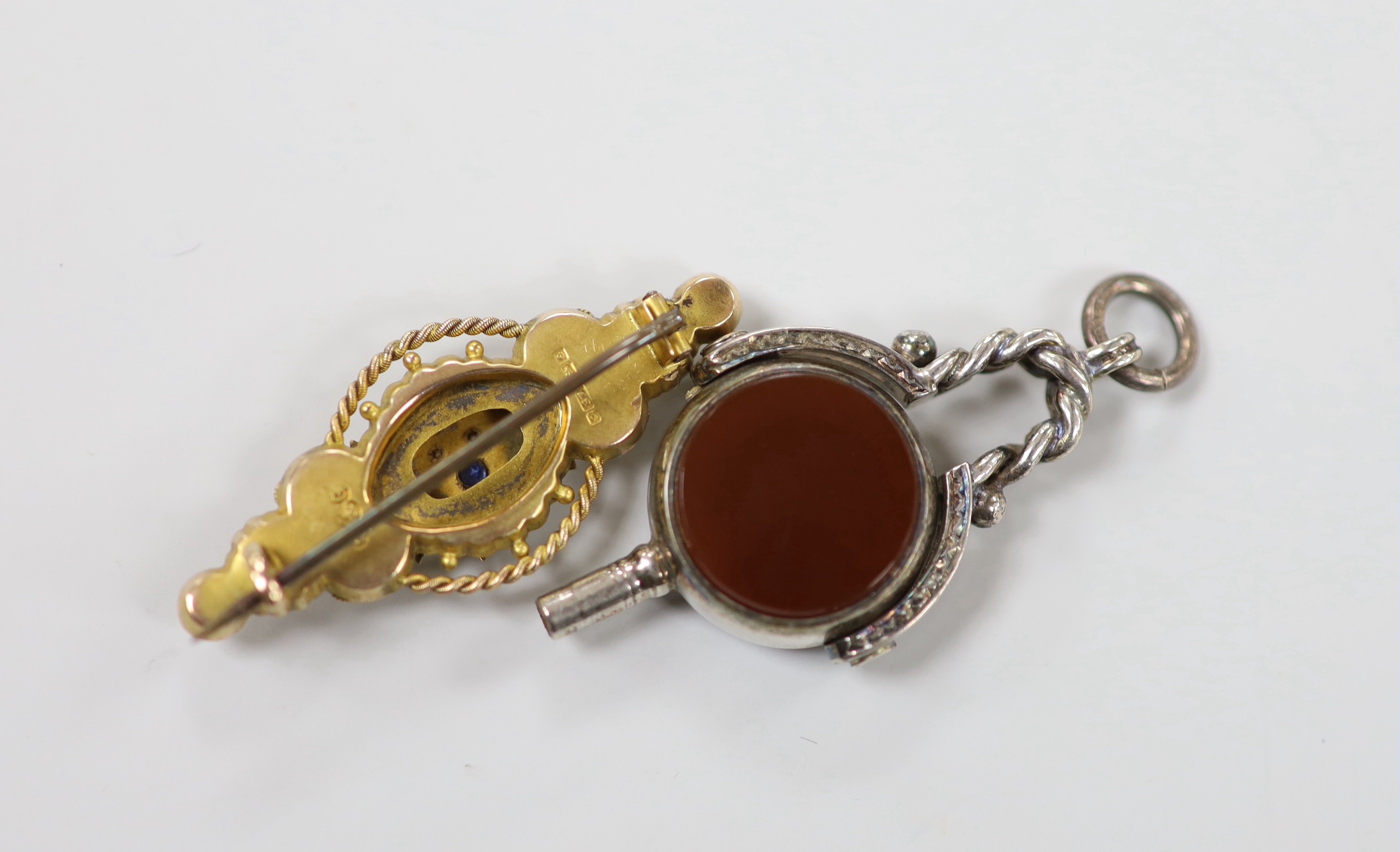 An Edwardian 9ct gold, sapphire and diamond chip set three stone brooch, 41mm, gross weight 33 grams and a bloodstone and carnelian set white metal spinning fob watch key.